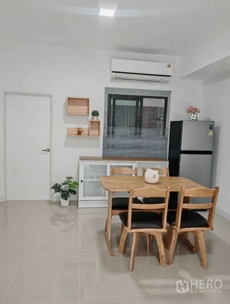 ทาวน์เฮาส์ ให้เช่าในBang Phli, Samut Prakan - มุมทานอาหาร โต๊ะไม้ 4 ที่นั่ง มู่ลี่ชั้นวางของ ผนัง และเครื่องปรับอากาศ
