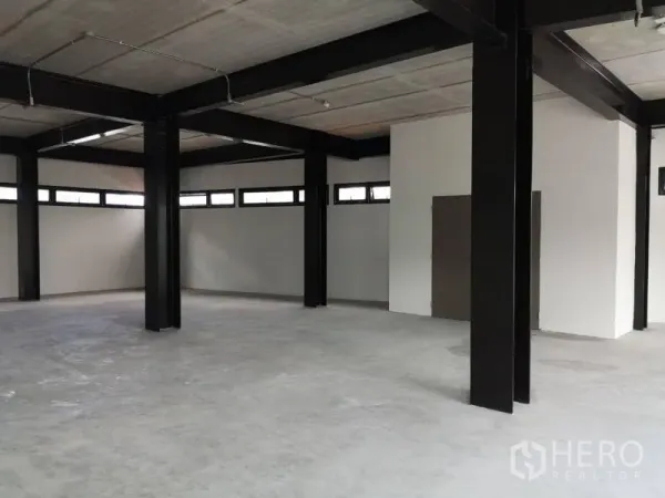 办公空间 出租在Chatuchak, Bangkok - 未配家具的工作区，黑色立柱、长条高窗与平整水泥地。