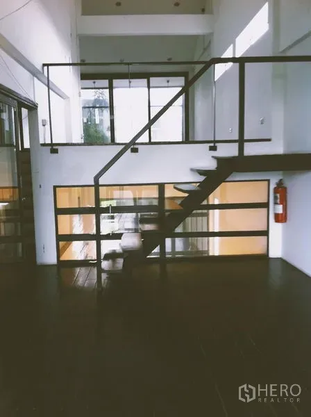 สำนักงานที่บ้าน ให้เช่าในChatuchak, Bangkok - บันไดขึ้นชั้นลอย ผนังกระจก และพื้นไม้โทนเข้มในพื้นที่ทำงานโปร่ง