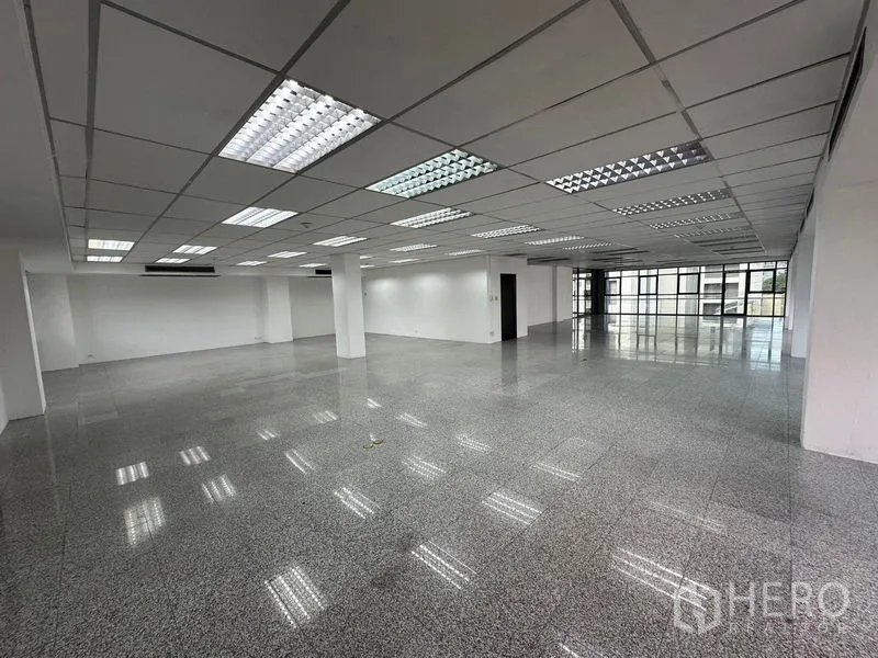 สำนักงาน ให้เช่า - ห้องทำงานขนาดกว้างพร้อมไฟฟลูออเรสเซนต์ เสาโครงสร้าง และผนังกระจกด้านใน