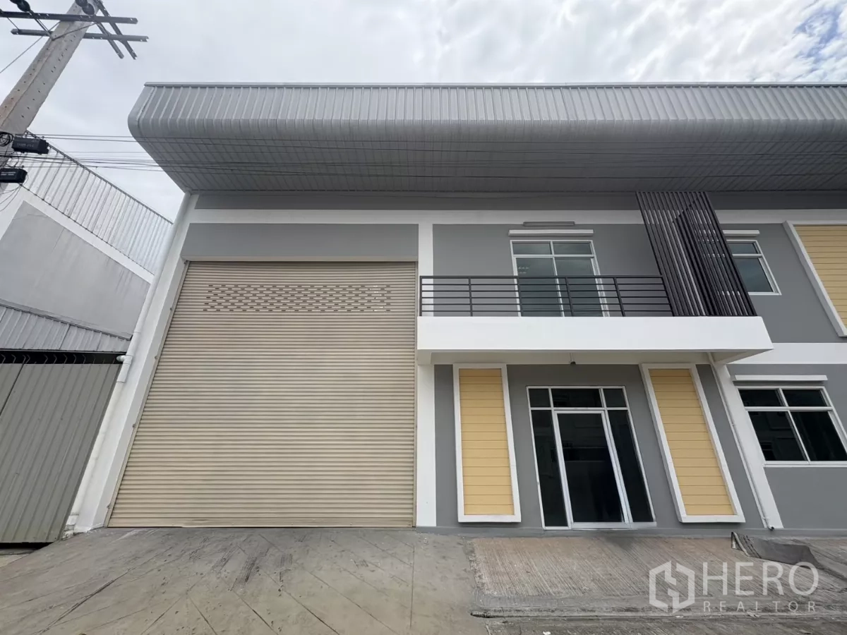 工厂 出租在Phra Samut Chedi, Samut Prakan - 靠近入口的视角，可见超大卷帘门与玻璃前台办公室。