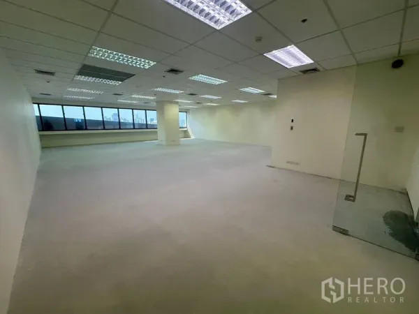 办公空间 出租在Bang Na, Bangkok - 未装修的办公室单元，玻璃入户门、嵌入式照明和侧面长窗。