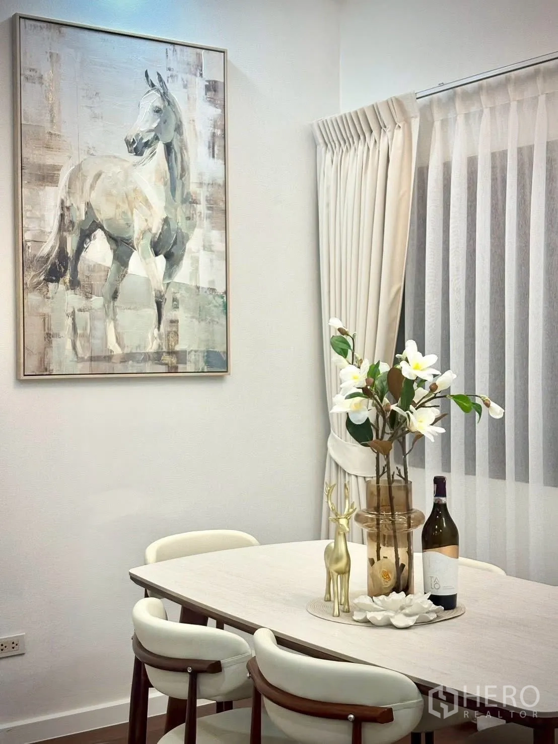 联排别墅 for rent in Huai Khwang, Bangkok - 用餐角落，浅色餐桌四椅、马主题装画与纱帘。