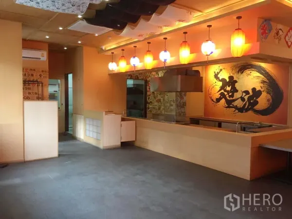 零售空间 出租在Khlong Toei, Bangkok - 温馨零售室内，开放式服务吧台，排烟罩，吊灯与墙面装饰画。