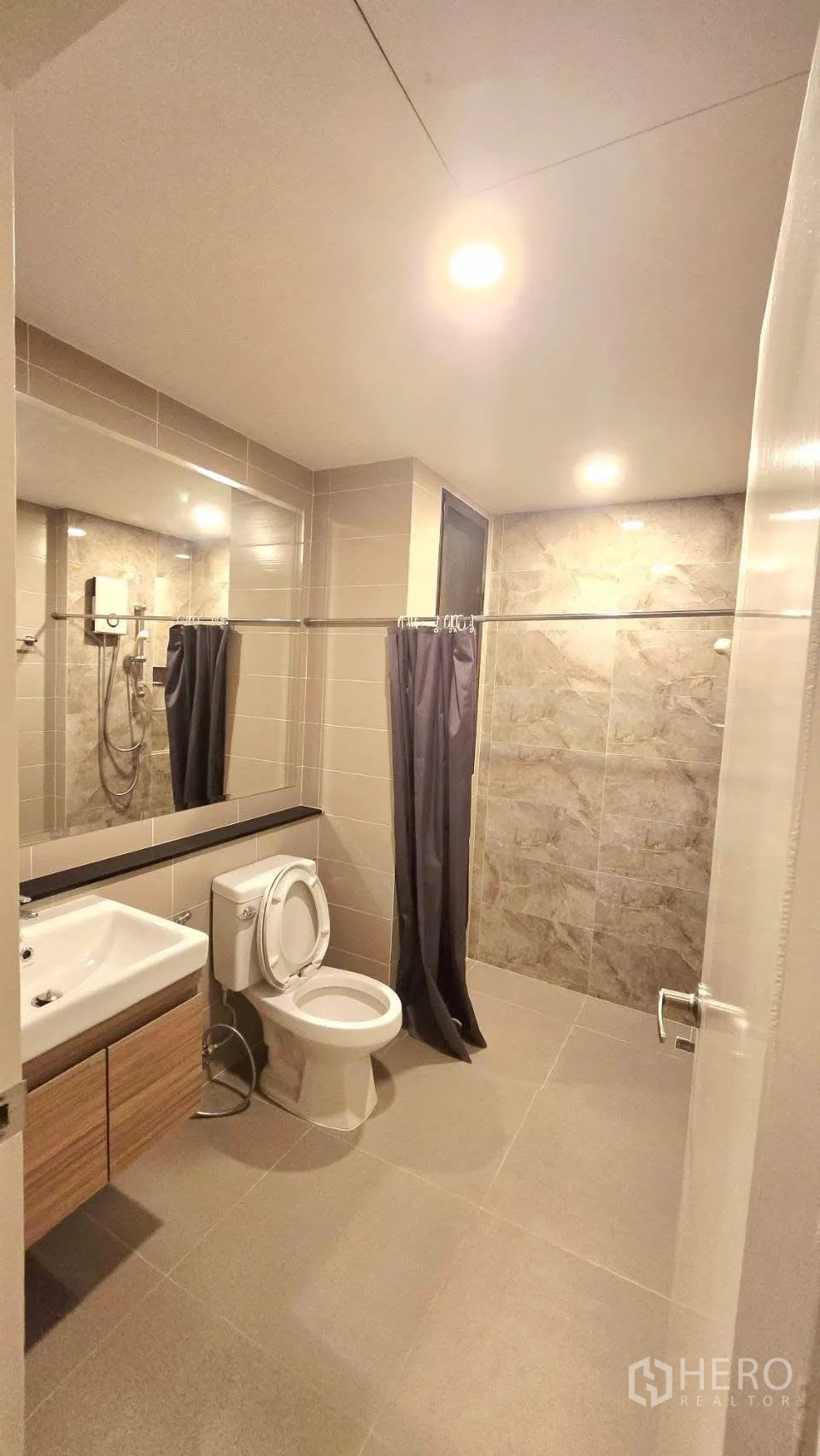 Detached House for rent in Prawet, Bangkok - Bathroom featuring a shower unit, vanity, toilet and stone-style tiles.