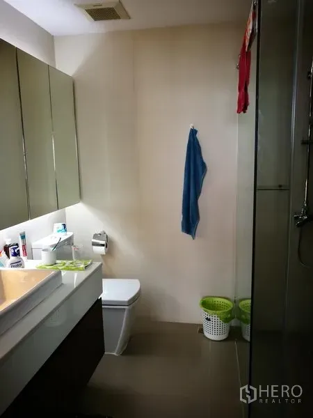 公寓 出租或出售在Watthana, Bangkok - 现代化浴室，带玻璃淋浴间、悬挂式洗手台和坐便器。