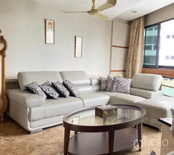 คอนโด ให้เช่าในKhlong Toei, Bangkok - มุมพักผ่อนสว่างด้วยโซฟาหนังทรง L พัดลมเพดาน และหน้าต่างบานใหญ่
