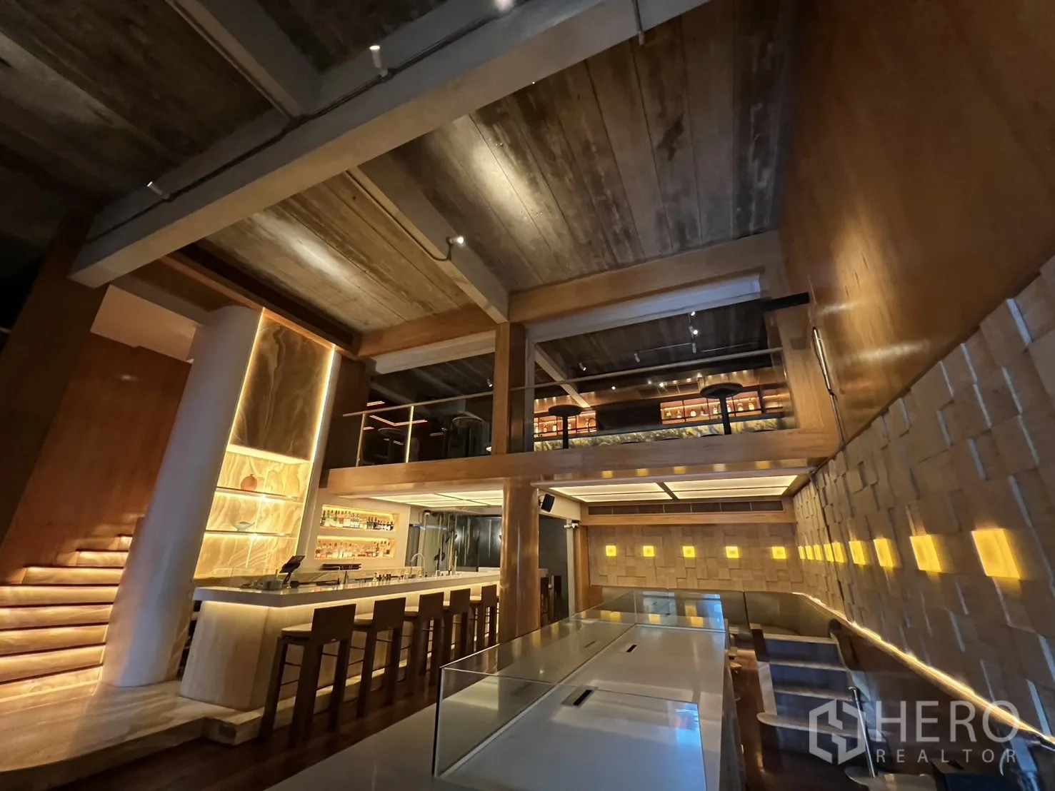 零售空间 出租在Watthana, Bangkok - 双层挑高的室内空间，木质装饰、吧台与夹层座位。