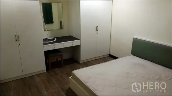 公寓 出租或出售在Khlong Toei, Bangkok - 第二卧室配有嵌入式衣柜、梳妆台、木地板与大床框。