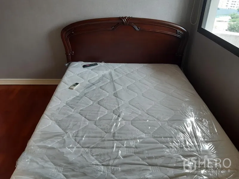 คอนโด ให้เช่าในKhlong Toei, Bangkok - ห้องนอนขนาดกะทัดรัด หัวเตียงไม้ ที่นอนใหม่ และแสงธรรมชาติจากหน้าต่าง