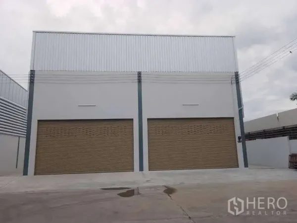 คลังสินค้า ให้เช่าในKhlong Toei, Bangkok - ด้านหน้าโกดังพร้อมประตูม้วนสีน้ำตาลสองบานและลานกว้าง