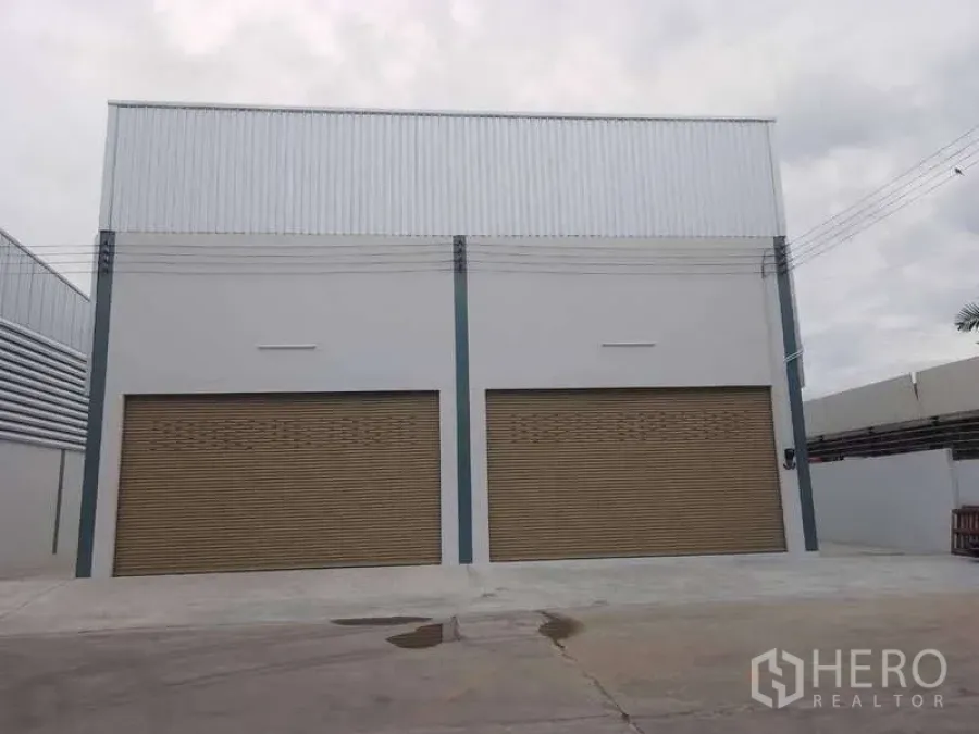 คลังสินค้า ให้เช่าในKhlong Toei, Bangkok - ด้านหน้าโกดังพร้อมประตูม้วนสีน้ำตาลสองบานและลานกว้าง