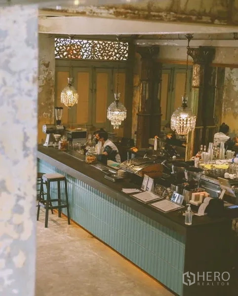 Shophouse for rent in Bang Rak, Bangkok - Daytime view of long turquoise bar counter with chandeliers and retro columns.