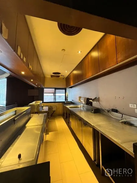 พื้นที่ขายปลีก ให้เช่า - ไลน์เสิร์ฟพร้อมเคาน์เตอร์สแตนเลสและตู้แช่ใต้เคาน์เตอร์ข้างตู้ไม้.