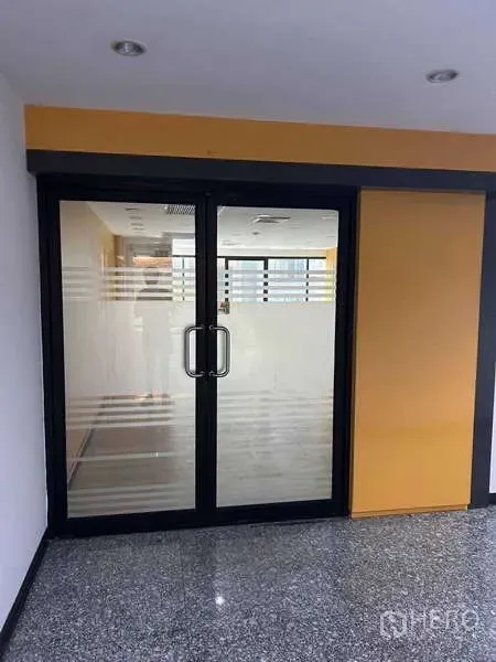 办公空间 出租在Khlong Toei, Bangkok - 办公单元入口，双开玻璃门配磨砂线条，通向室内。