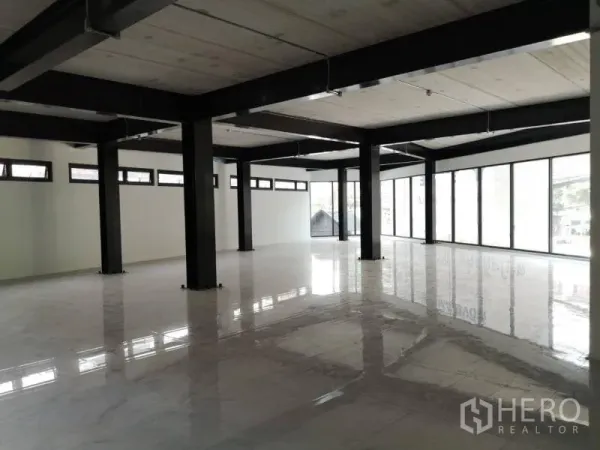 办公空间 出租在Chatuchak, Bangkok - 开放式办公室内部，黑色钢柱、亮面白色地砖与整面落地窗。