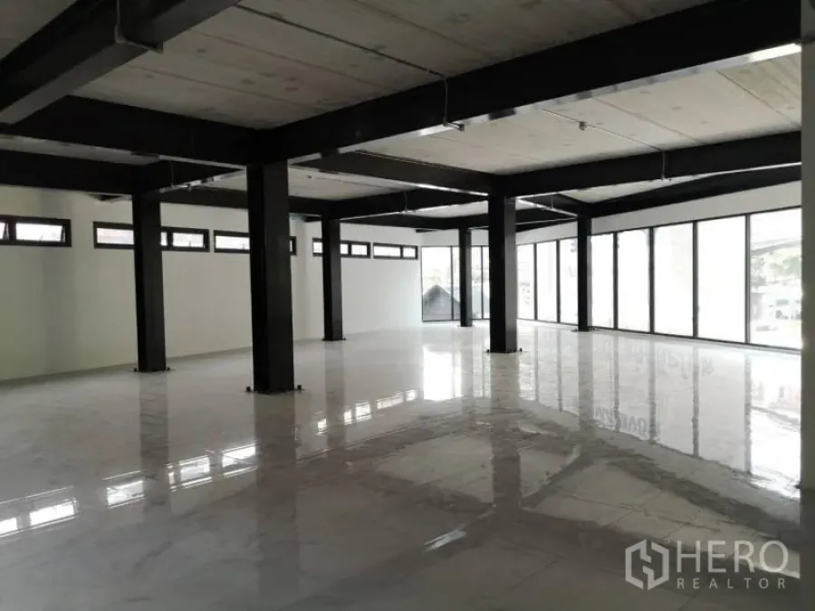 办公空间 出租在Chatuchak, Bangkok - 开放式办公室内部，黑色钢柱、亮面白色地砖与整面落地窗。