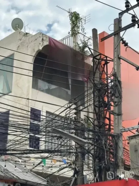 店屋 出租在Ratchathewi, Bangkok - 多层商铺楼上部外立面，带小阳台和密集的空中电缆。