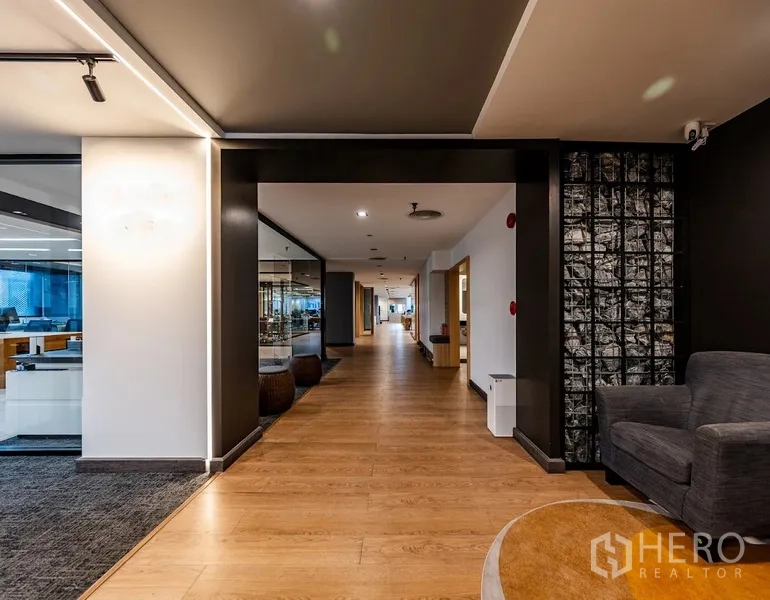 办公室 for rent in Bang Rak, Bangkok - 木地板宽走廊，穿过两侧玻璃墙办公室和会议室。