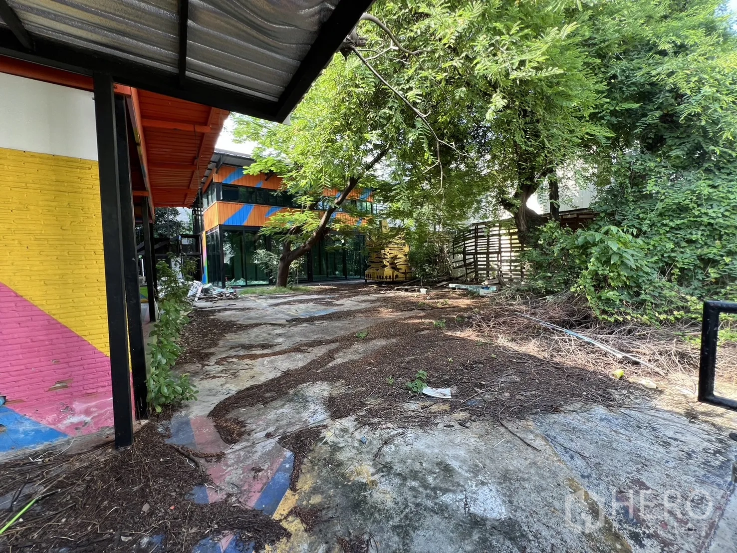 Detached House for rent in Watthana, Bangkok - Walkway view across the courtyard toward the glass pavilion and trees.