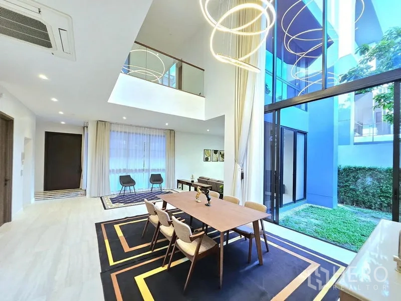 Detached House for rent in Bang Kapi, Bangkok - Expansive double‑height dining space with glass wall and garden view