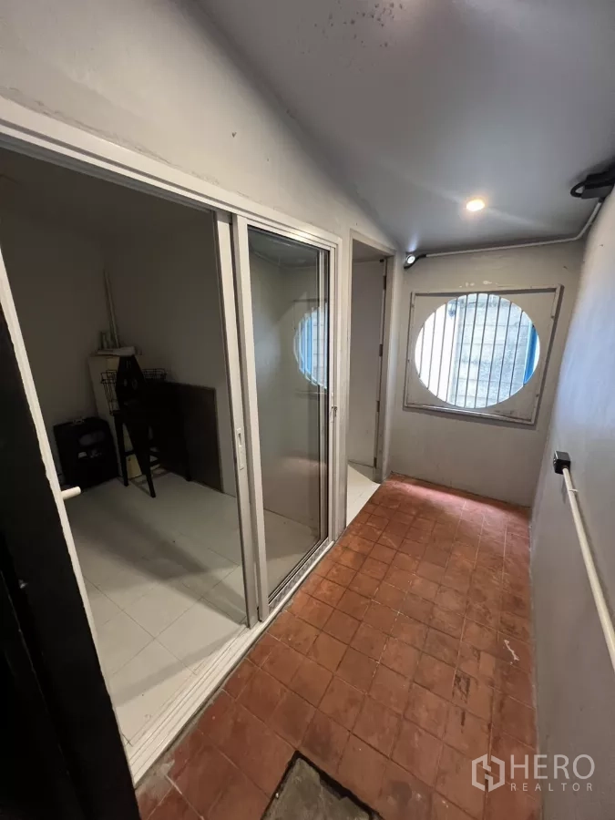 店屋 出租在Watthana, Bangkok - 走廊设玻璃推拉隔间，尽头为圆形窗。