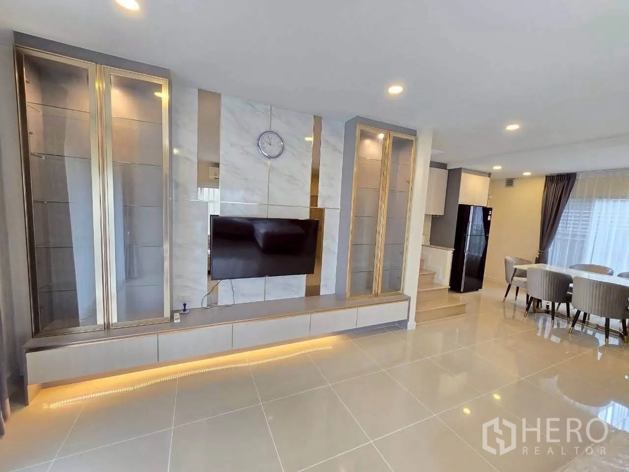 Detached House for rent or sale in Lat Krabang, Bangkok - Open-plan lounge with feature TV wall, recessed lighting, and dining view.