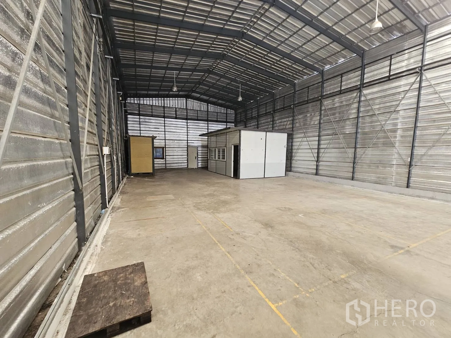 Warehouse for rent in Bang Phli, Samut Prakan - Back section of the warehouse with marked floor lines, side windows, and small office cabins.