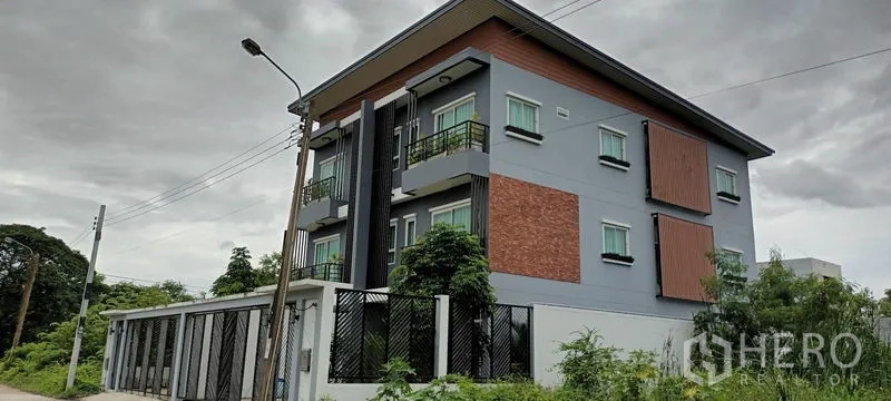 联排别墅 出租或出售在Saphan Sung, Bangkok - 现代三层联排别墅外观，带阳台、红砖装饰与隐私百叶。