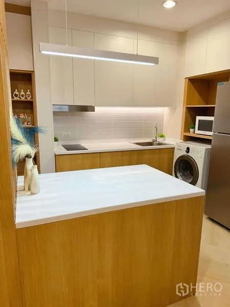 คอนโด ให้เช่าในChatuchak, Bangkok - ครัวบิวท์อิน เคาน์เตอร์สีขาว ตู้ไม้ โคมไฟแขวน ตู้เย็น และเครื่องซักผ้าในห้อง