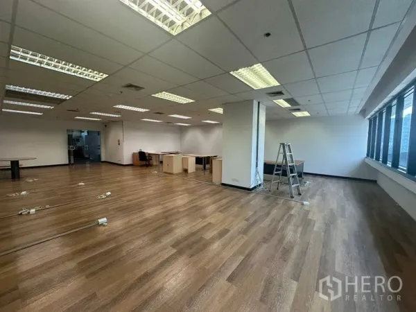 办公空间 出租在Bang Rak, Bangkok - 一侧全景窗、居中立柱与地面布线端口的办公室。