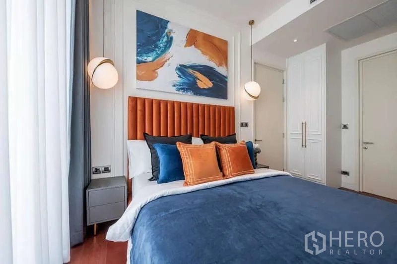 公寓 出租或出售在Watthana, Bangkok - 明亮卧室，橙色软包床头、吊灯与抽象画