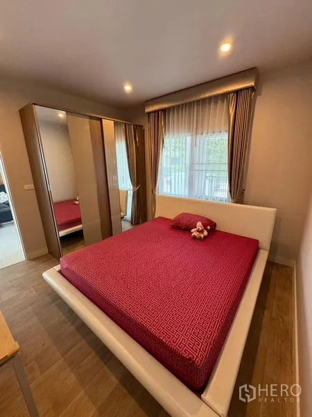 Detached House for rent in Prawet, Bangkok - Cozy bedroom with red bedding, wardrobe and large windows.