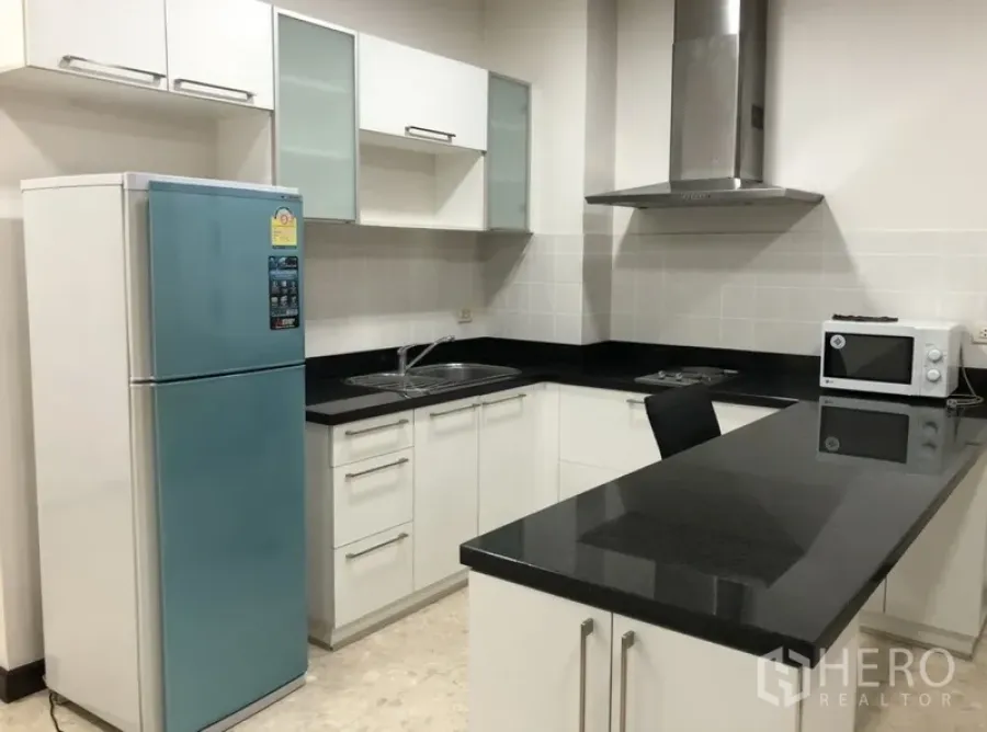 คอนโด ให้เช่าในKhlong Toei, Bangkok - ครัวรูปตัวแอล เคาน์เตอร์หินสีดำ เครื่องดูดควัน เกาะครัว และตู้เย็นสองประตูสีฟ้า