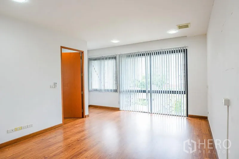 联排别墅 出租在Watthana, Bangkok - 宽敞卧室，落地窗与阳台门，配竖百叶