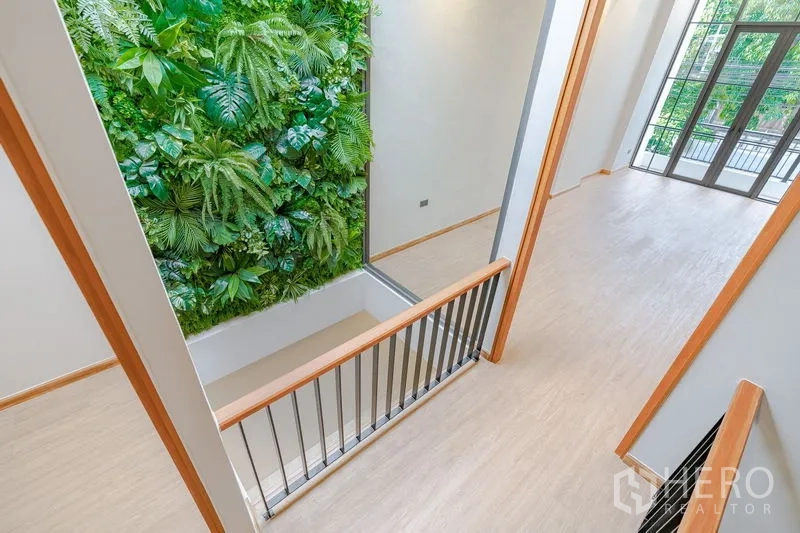 Townhouse for sale - Stair landing beside a striking indoor vertical green wall feature.