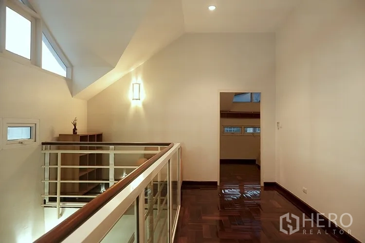 Apartment for rent in Khlong Toei, Bangkok - Upper mezzanine landing with railing and wood floors in duplex