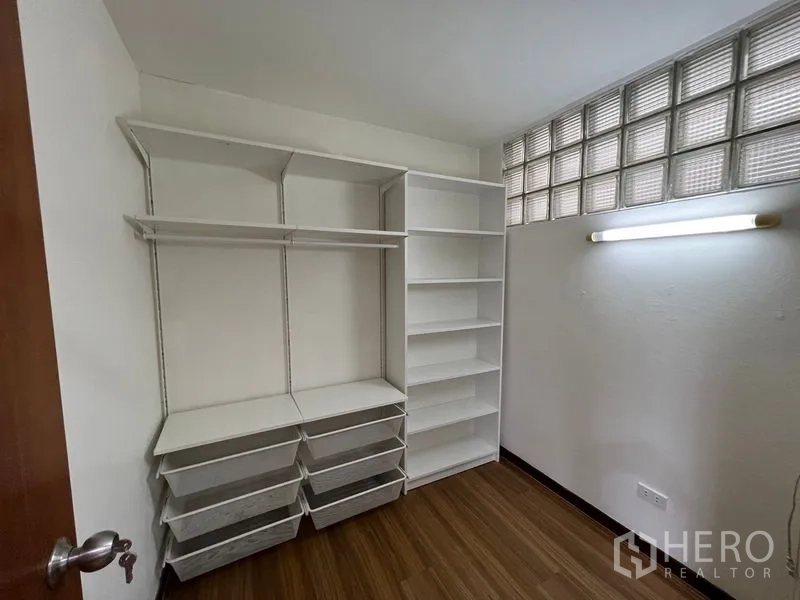 ทาวน์เฮาส์ ให้เช่าหรือขายในSuan Luang, Bangkok - ห้องแต่งตัววอล์กอินติดตั้งชั้นและลิ้นชักสีขาว ข้างหน้าต่างบล็อกแก้ว