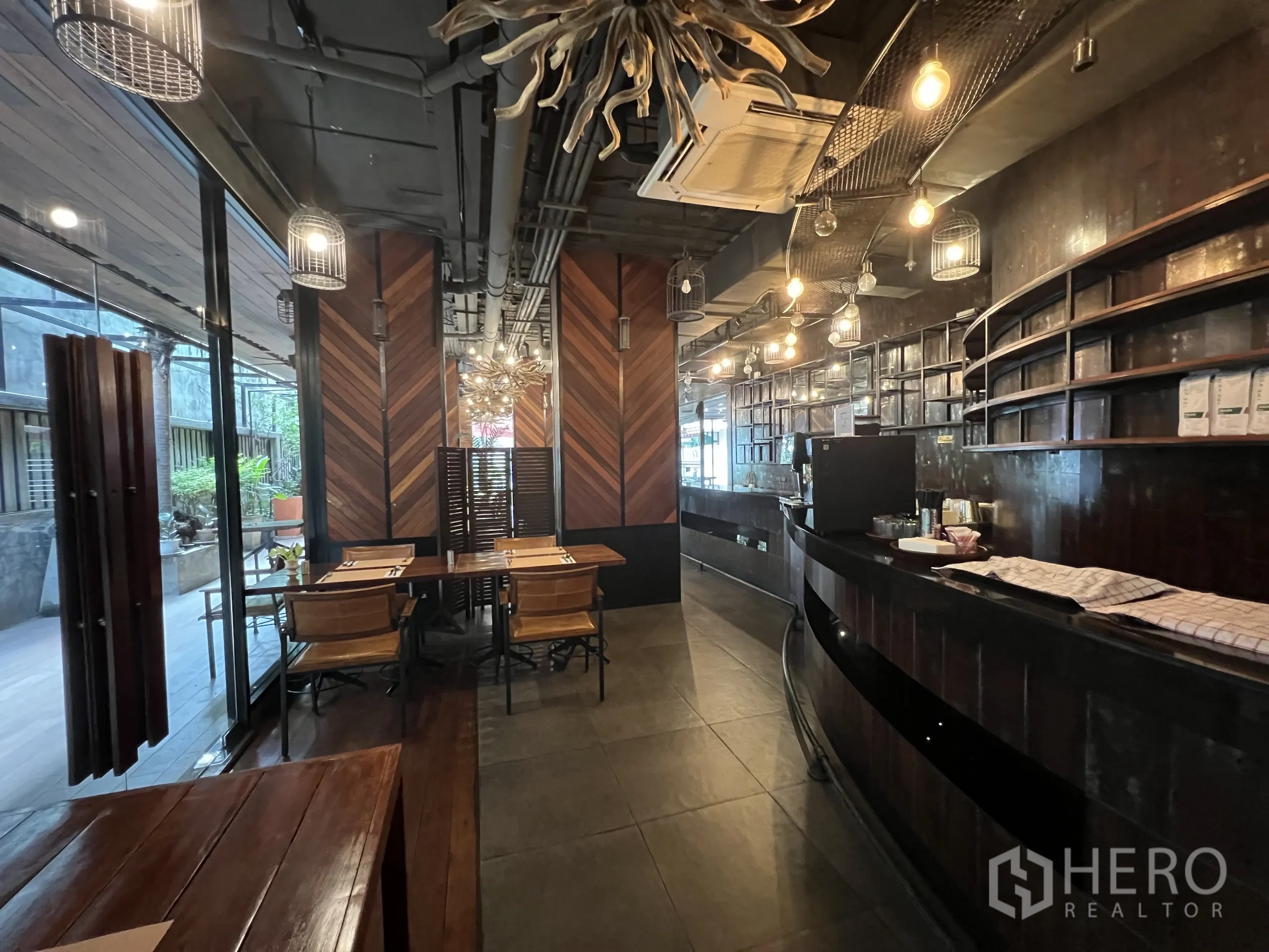 พื้นที่ขายปลีก ให้เช่าในWatthana, Bangkok - เคาน์เตอร์บาร์โค้งพร้อมชั้นวาง โต๊ะเก้าอี้ และประตูกระจกออกสู่ระเบียง