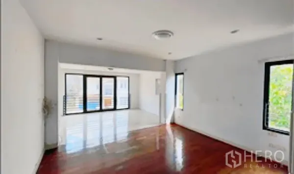 独立式住宅 出售在Khan Na Yao, Bangkok - 明亮客厅，木地板，嵌灯，大幅玻璃门通向露台