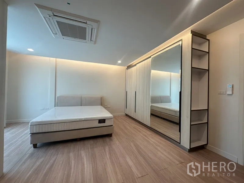 ทาวน์เฮาส์ ให้เช่าในWatthana, Bangkok - ห้องนอนใหญ่พร้อมตู้เสื้อผ้าบานกระจกเต็มผนังและพื้นไม้