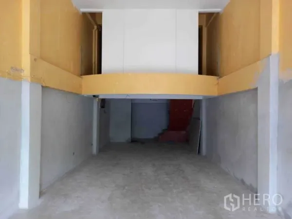 店屋 出租在Watthana, Bangkok - 一层空置店铺空间，挑高天花与夹层，水泥地面。