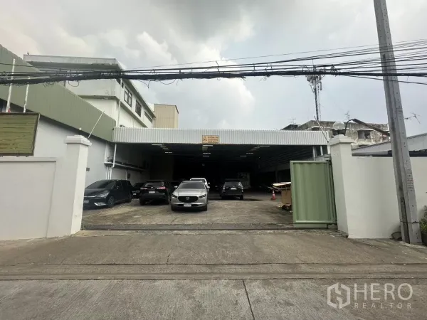 คลังสินค้า ให้เช่าในYan Nawa, Bangkok - ทางเข้าหน้าอาคารมุ่งสู่ลานขนถ่ายสินค้าที่มีหลังคาคลุมและรถจอดหลายคัน