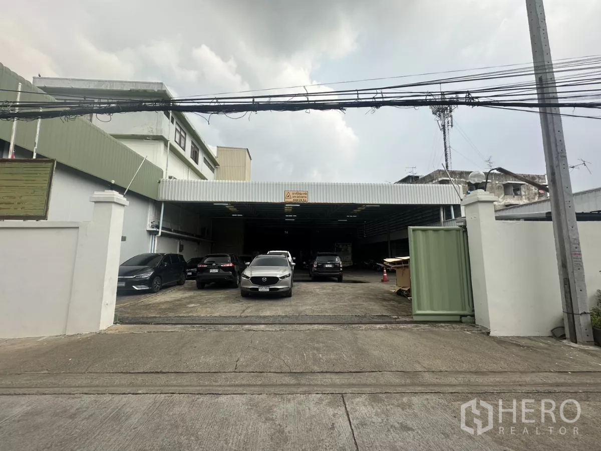 คลังสินค้า ให้เช่าในYan Nawa, Bangkok - ทางเข้าหน้าอาคารมุ่งสู่ลานขนถ่ายสินค้าที่มีหลังคาคลุมและรถจอดหลายคัน