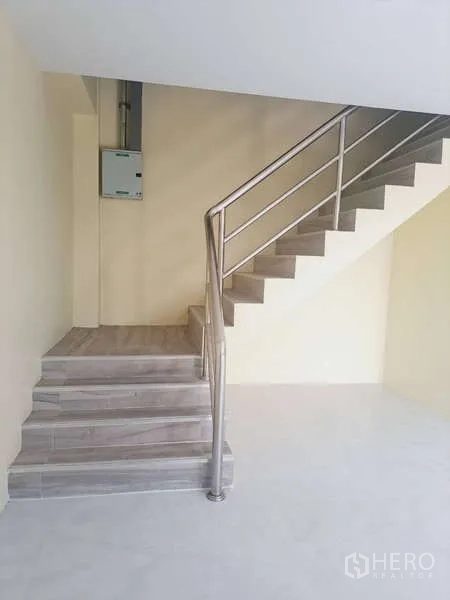 货栈 出租在Mueang Samut Prakan, Samut Prakan - 室内楼梯，不锈钢扶手与木纹瓷砖踏步。