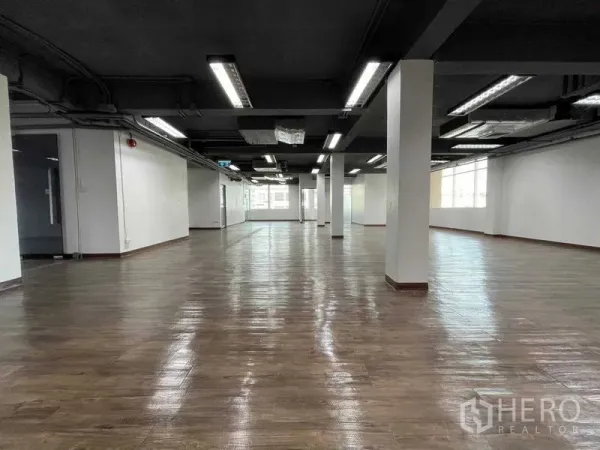 สำนักงาน ให้เช่าในRatchathewi, Bangkok - โถงออฟฟิศแบบโอเพ่นกว้าง เสาหลายต้น และไฟเส้นเหนือศีรษะ