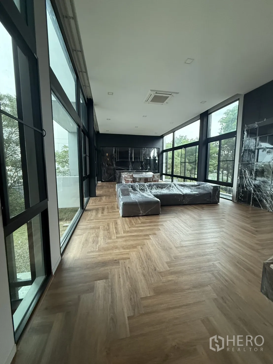 Detached House for rent in Saphan Sung, Bangkok - Open-plan lounge and dining area with panoramic glass walls and abundant natural light.