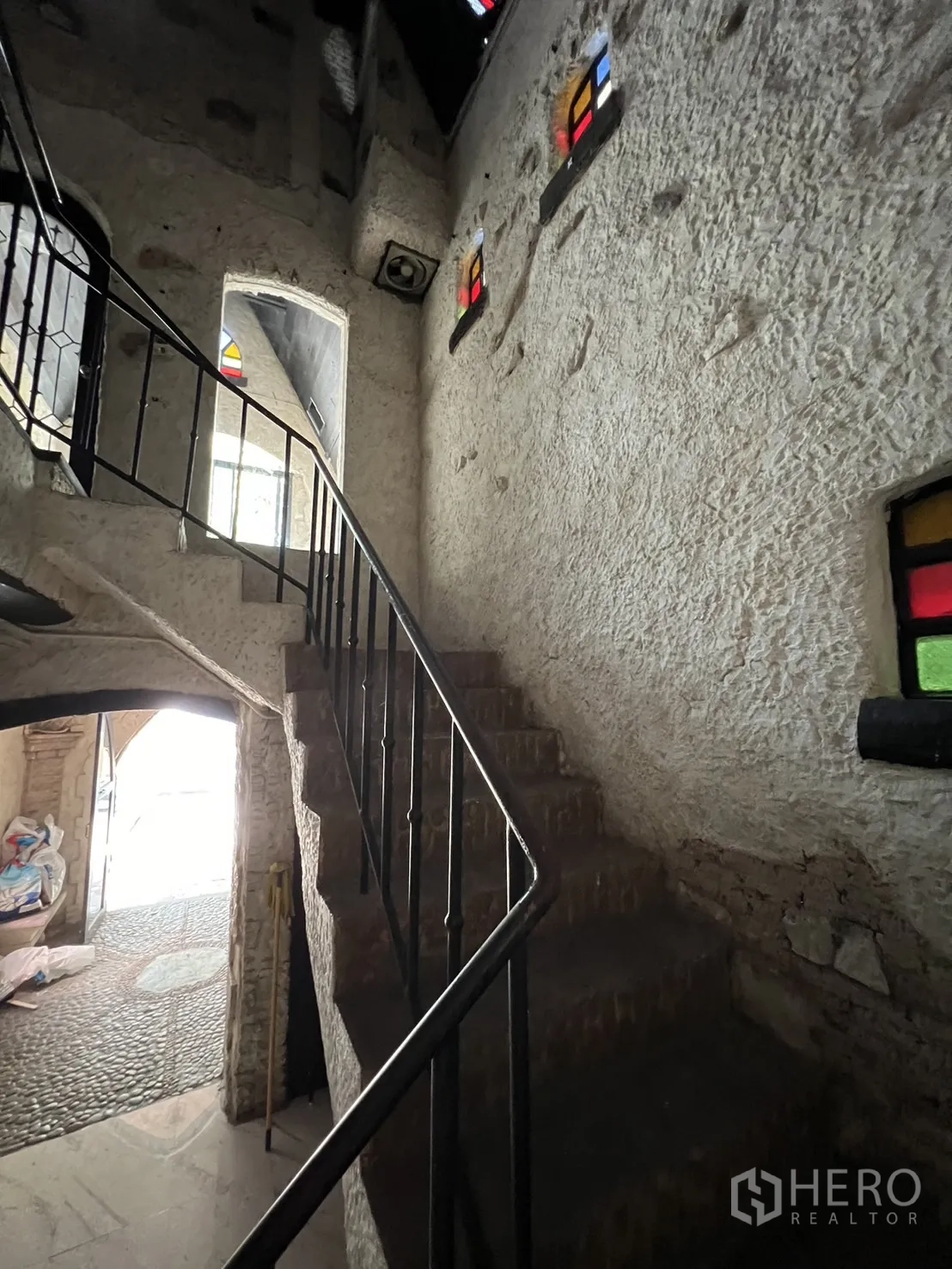 零售空间 出租在Watthana, Bangkok - 楼梯间，粗糙抹灰墙、铁质扶手与拱形彩窗。