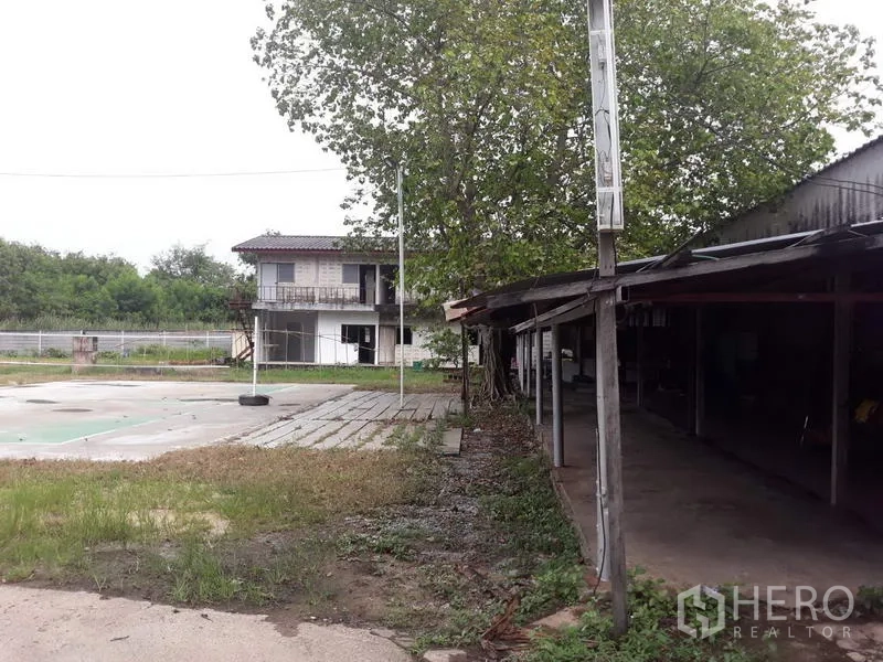 โรงงาน ให้เช่าในThanyaburi, Pathum Thani - ลานด้านนอก มีต้นไม้ อาคารย่อย และโรงเรือนหลังคากันสภาพอากาศ