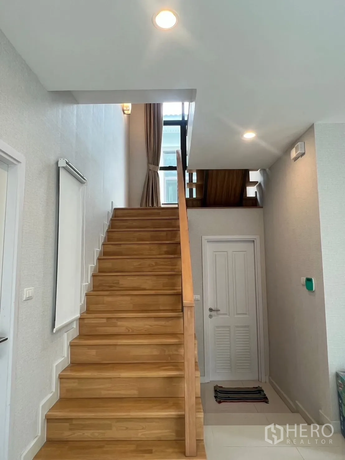 Detached House for rent in Bang Phli, Samut Prakan - Wooden staircase in a two-storey home with tall window and neutral walls.